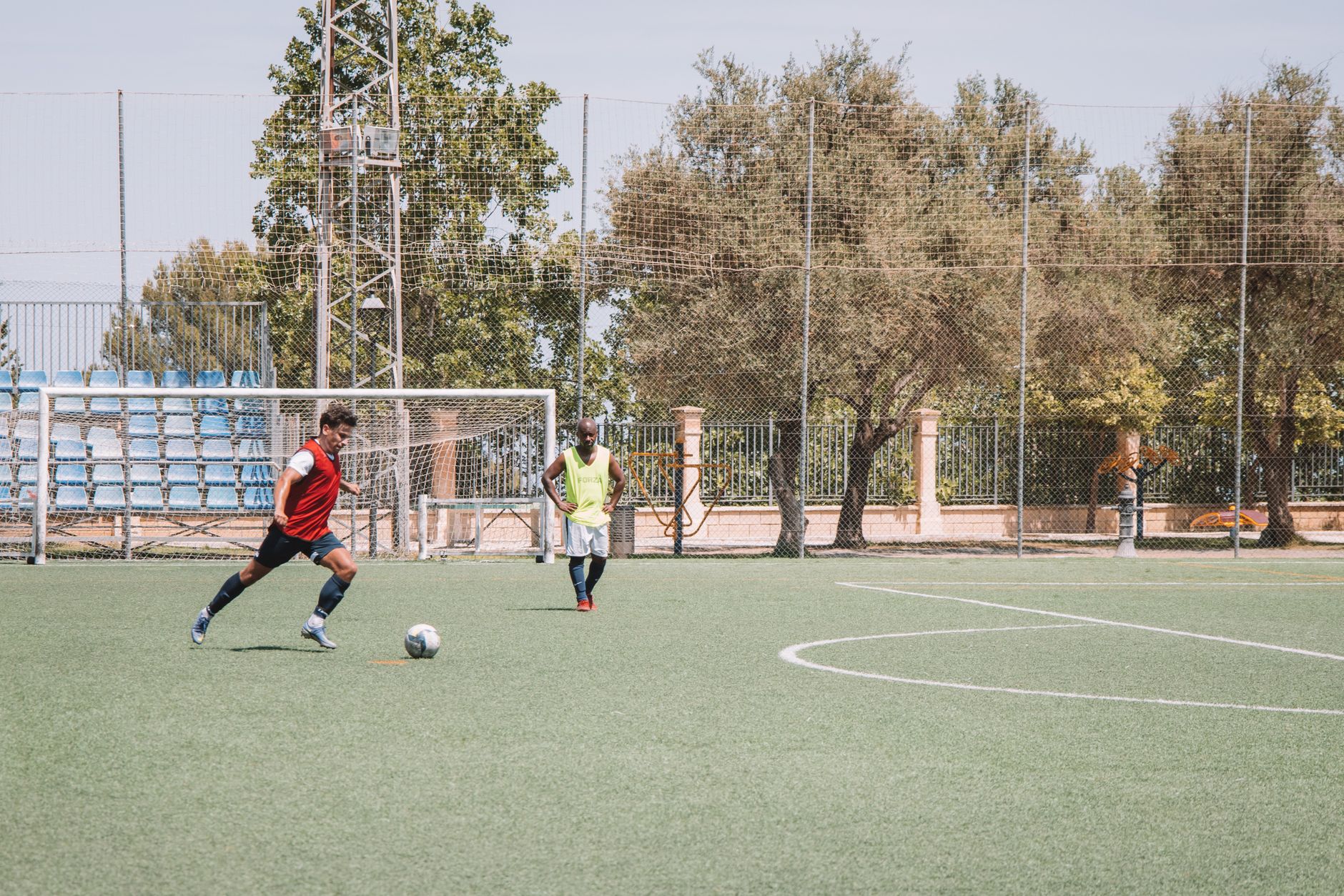Two soccer players practicing on an outdoor pitch in Málaga, Spain.
