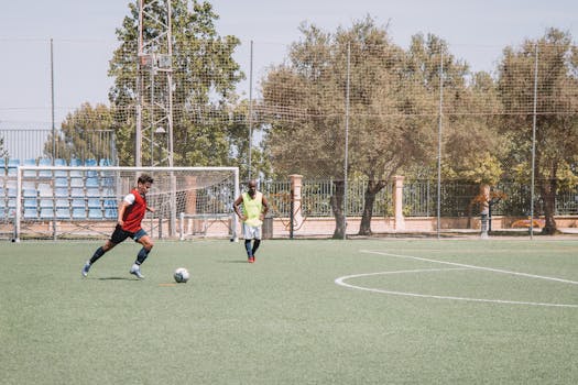 Two soccer players practicing on an outdoor pitch in Málaga, Spain.