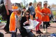 Children and adults enjoying King's Day in Haarlem, vibrant in orange with costumes and outdoor activities.