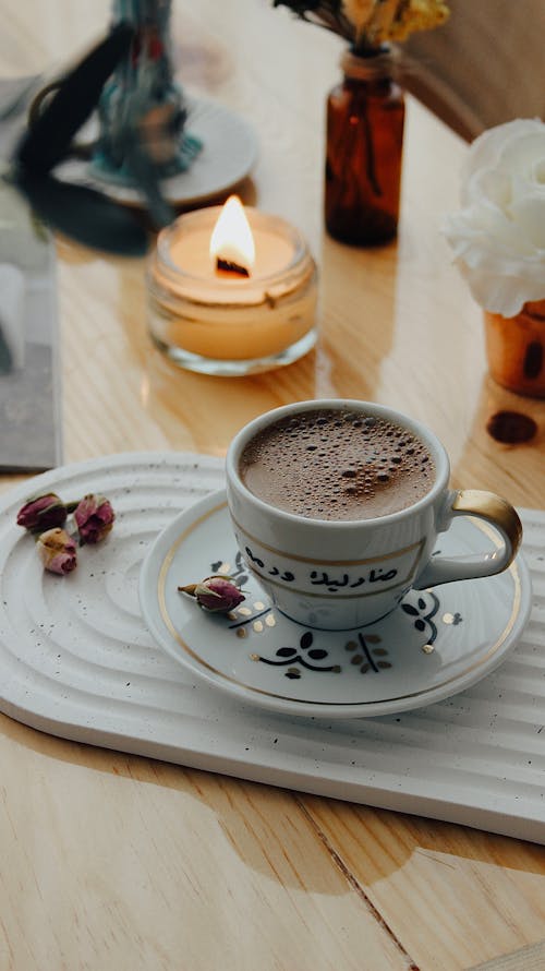 Cup of Coffee and a Candle on the Table 