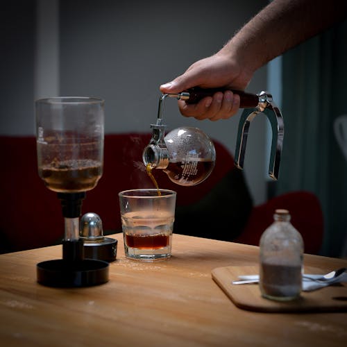 Pouring Coffee into Glass on Table