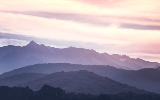 日出时分，迷人的山地景观与柔和的天空，展现了大自然的宁静
