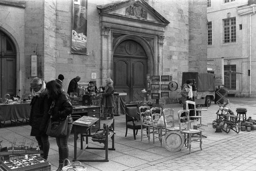 Free Black and white photo of a vintage flea market in Nancy, France, showcasing antiques and urban architecture. Stock Photo