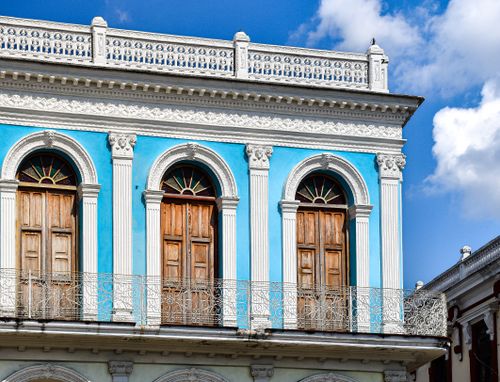Free Vibrant colonial-style building facade with ornate balconies in Sancti Spiritus, Cuba. Stock Photo