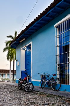 Vibrant blue house and classic bikes in the charming streets of Trinidad, Cuba.