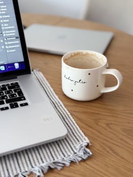 A cozy scene with a coffee mug and laptop on a wooden table, perfect for morning routines in Montenegro.