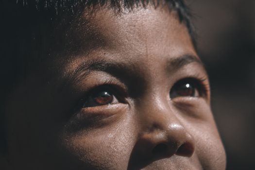 Intimate close-up of a child gazing skyward, capturing emotion and detail.