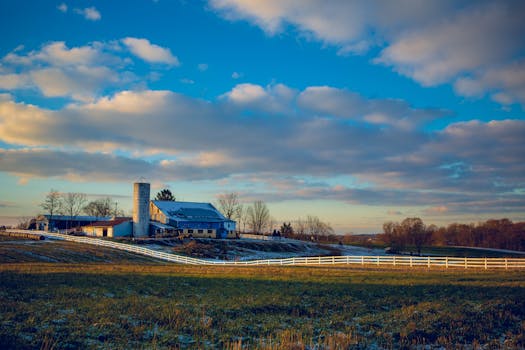 Picturesque rural farm landscape with an expansive sky and vibrant clouds.