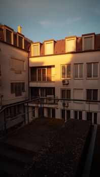 Sunset light casts a warm glow on a residential building's facade with modern architecture.