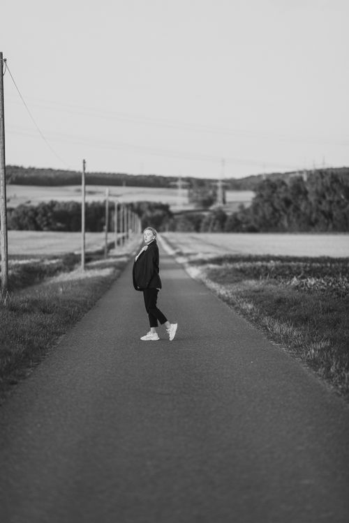 Free Artistic black and white portrait of a woman standing on a country road in Bockenem, Germany. Stock Photo