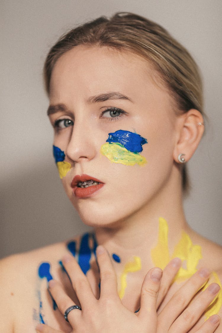 Woman With Blue And Yellow Paint On Her Skin 