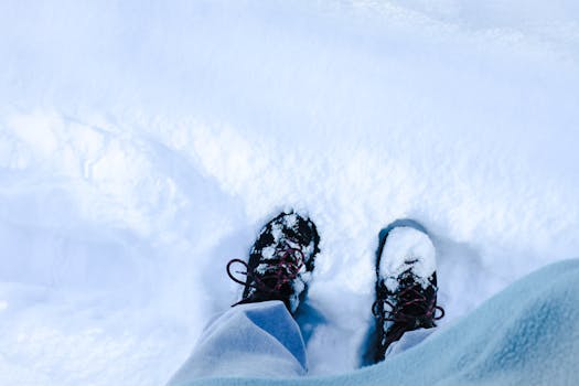 Top view of snow-covered boots standing in winter snow.