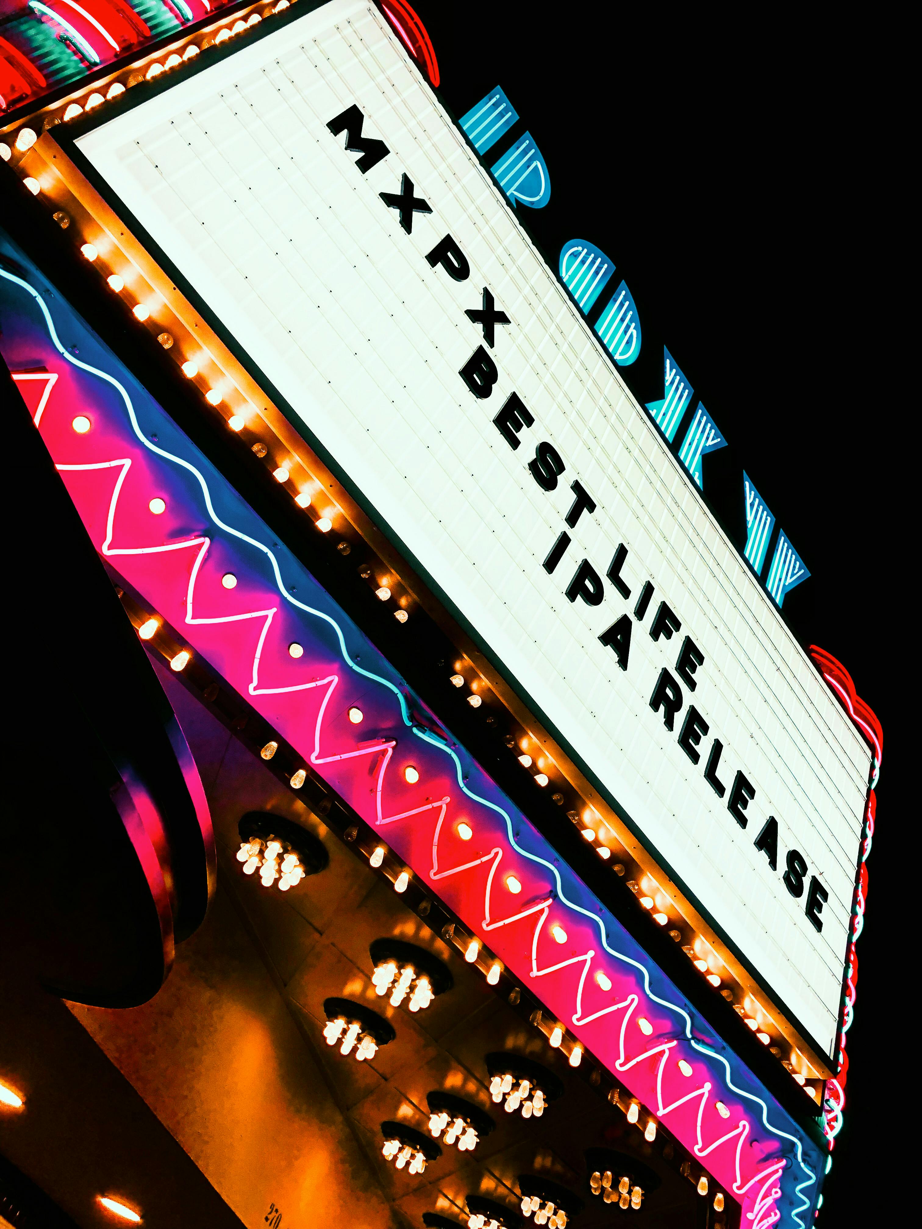 Free Vibrant neon-lit theater marquee showcasing 'MXPX Best Life IPA Release' at night. Stock Photo