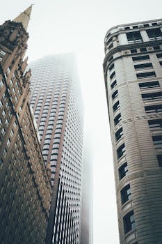 雾中的摩天大楼朦胧隐现，营造出空灵的城市景观