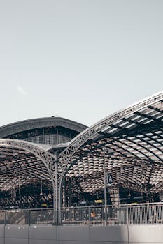 Captivating arch design of a contemporary train station roof, showcasing steel and glass elements.