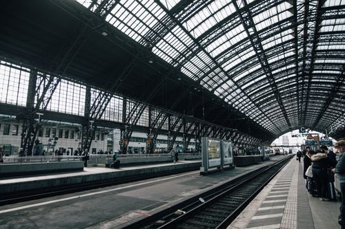 Free View of a bustling urban train station with commuters on the platform. Stock Photo