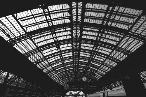 Free Dramatic black and white view of a modern train station's architectural ceiling. Stock Photo