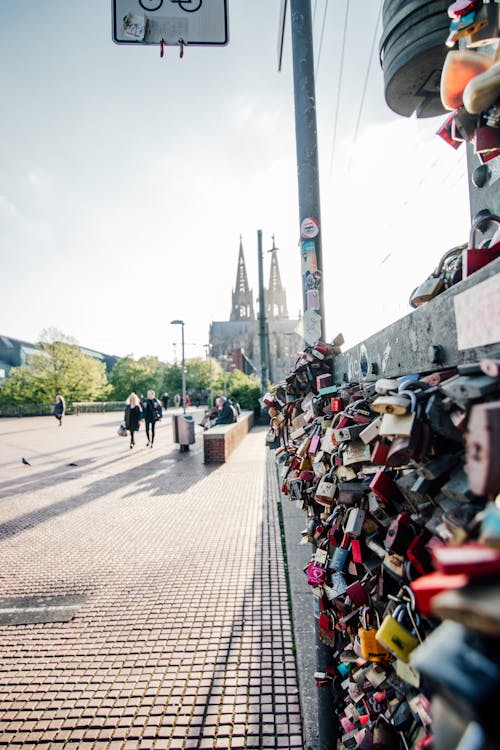 A bunch of padlocks on a fence with a church in the background
