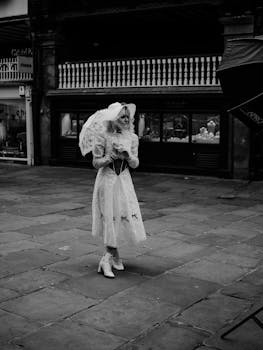 A woman in vintage fashion posing elegantly in an urban street setting, exuding retro charm.