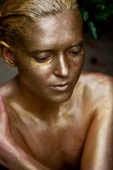 镜头特写一位女性，她身上涂着闪闪发光的金色人体彩绘，展现了艺术之美