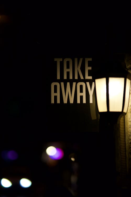 Close-up of a Lantern and a Sign of a Restaurant in City at Night 