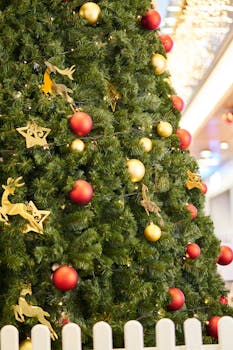 室内装饰精美的圣诞树，挂满了红色和金色的装饰品，还点缀着节日灯光
