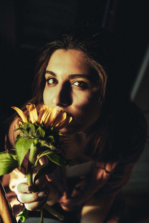 Young Woman with Flower in Dark