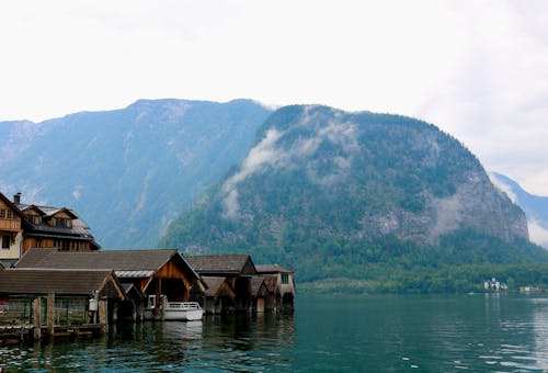 Free Lakeshore Boathouses with a Mountain in the Background Stock Photo