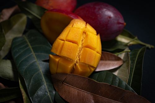 Free Close-up of ripe mango slices on tropical leaves, showcasing vibrant colors and textures. Stock Photo
