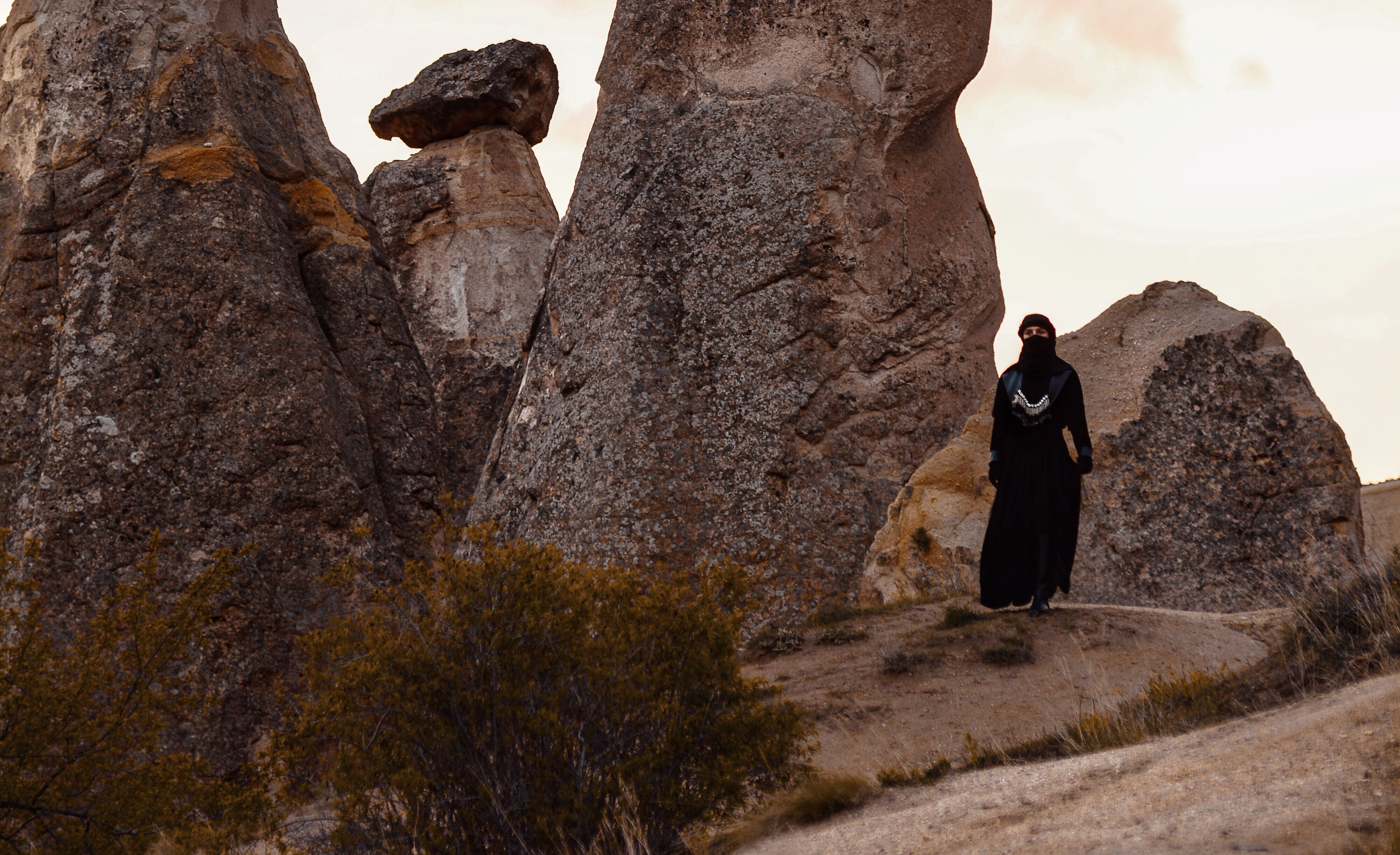 Woman Wearing Traditional Black Clothing Standing by Rocks · Free Stock ...