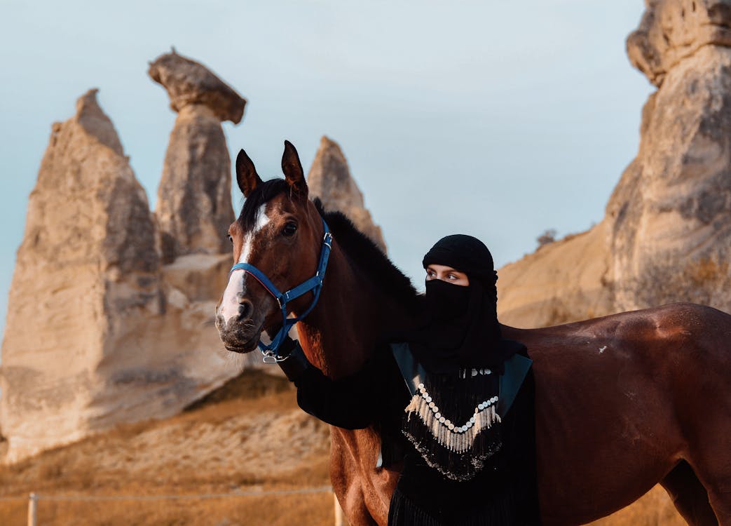 Woman Standing with a Horse in a Desert 