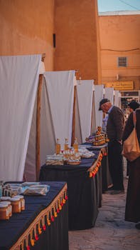Bustling street market scene with shoppers browsing local merchandise in rustic setting.
