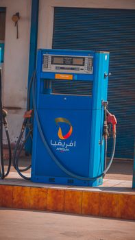 A bright blue fuel pump stationed outside, featuring Arabic script and Africquia logo.