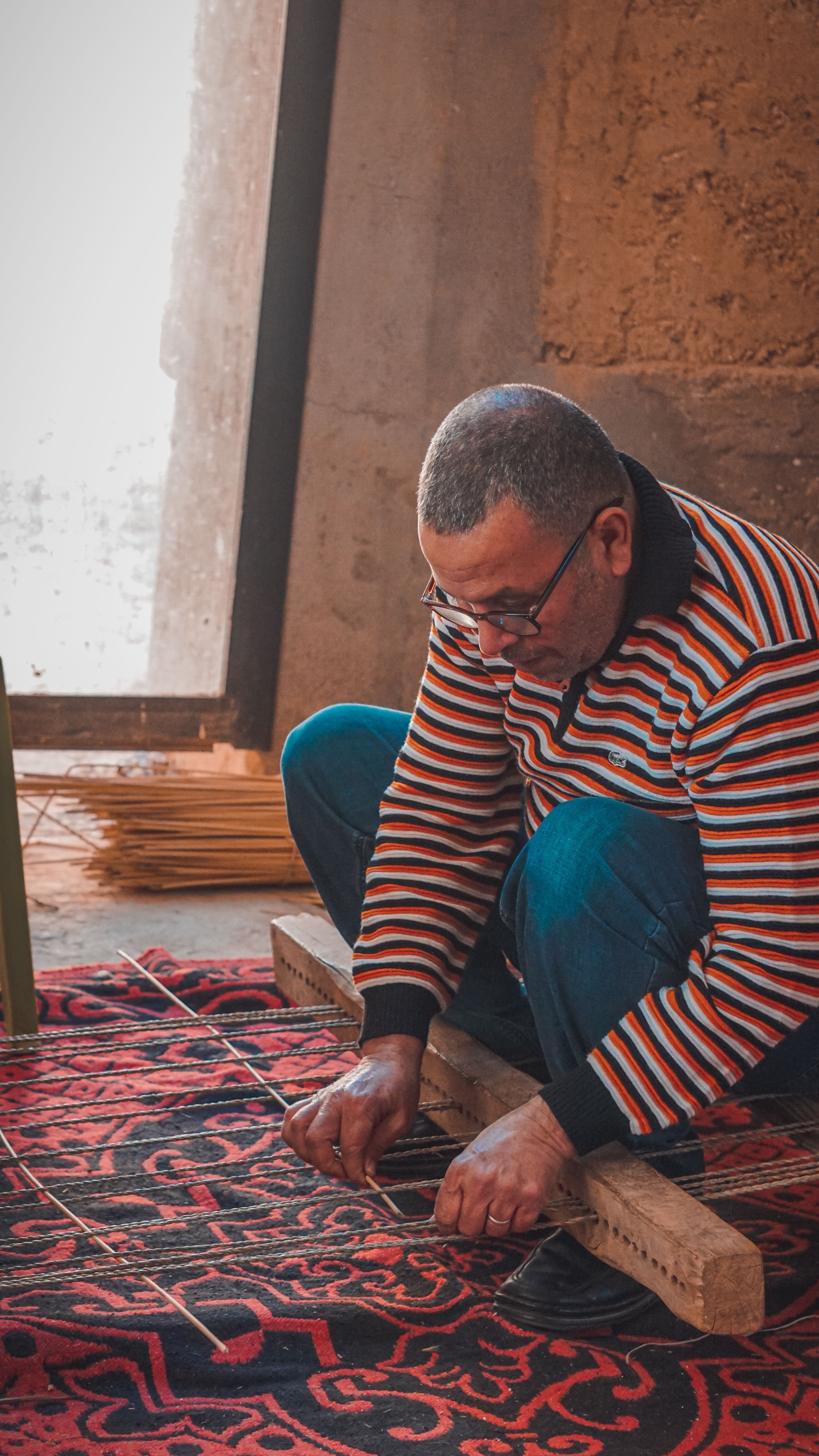 Artisan working on a detailed handmade rug