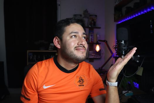 Portrait of a man in a home studio setting with a microphone, showcasing a thoughtful expression.