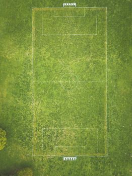 Drone shot of an empty soccer field with clearly marked white lines.