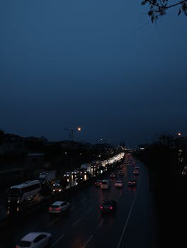 Night view of traffic on an urban highway, highlighting headlights and a busy expressway.