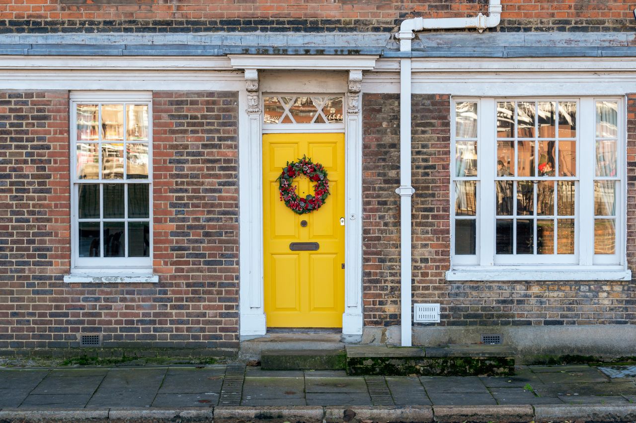 flag-themed-door-mat A house facade with a bright yellow front door