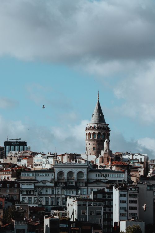 Free View of Galata Tower and Istanbul cityscape with dramatic clouds and urban architecture. Stock Photo