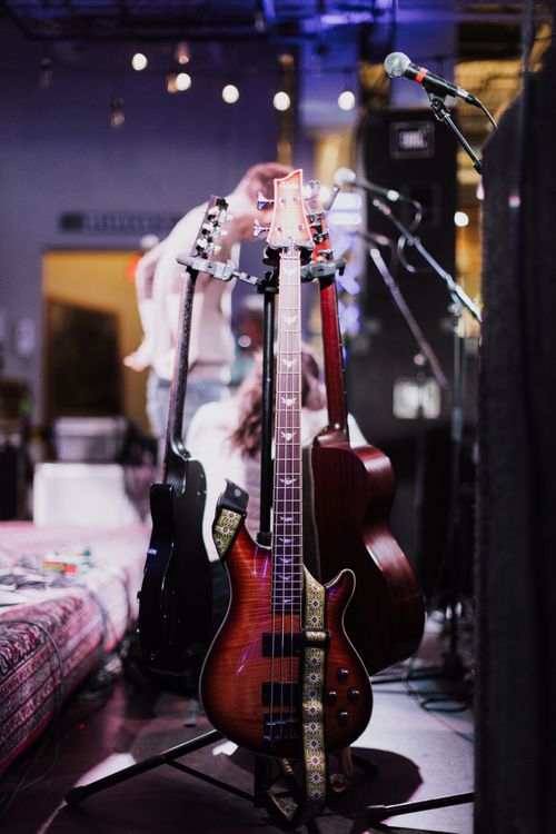 Free Vertical shot of various electric guitars stowed in a music studio with ambient lighting. Stock Photo