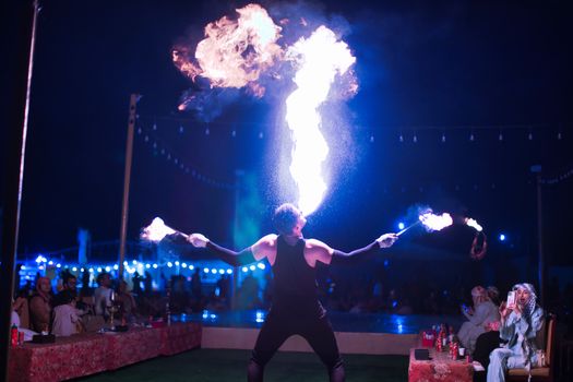 Performer Breathing and Juggling Fire at an Evening Show