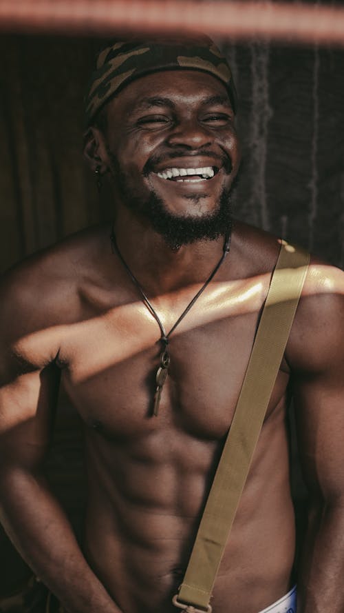 Smiling Shirtless Man Wearing Camouflage Cap