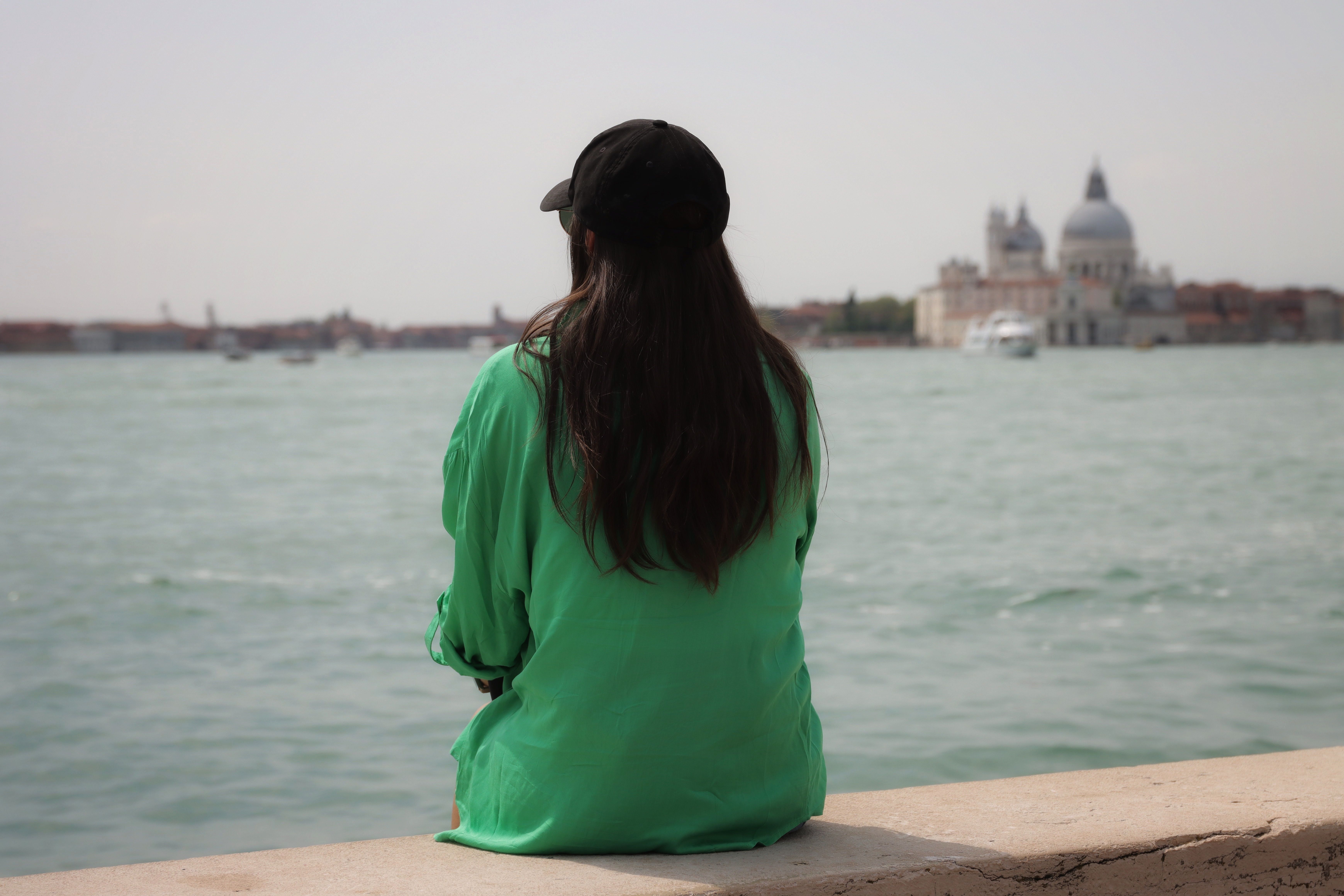 Back View of a Woman Sitting on a Wall Facing the Venetian Lagoon ...