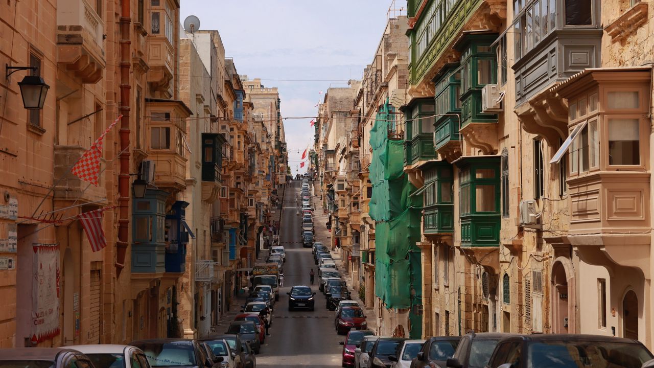 Colourful houses and parked cars on a street in Malta
