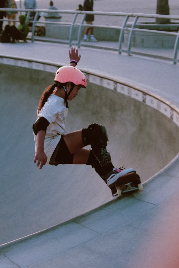 Girl In Helmet On Skateboard In Skate Park