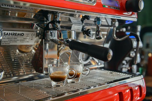 Close-up of Coffee Pouring from a Coffee Machine into Espresso Cups 
