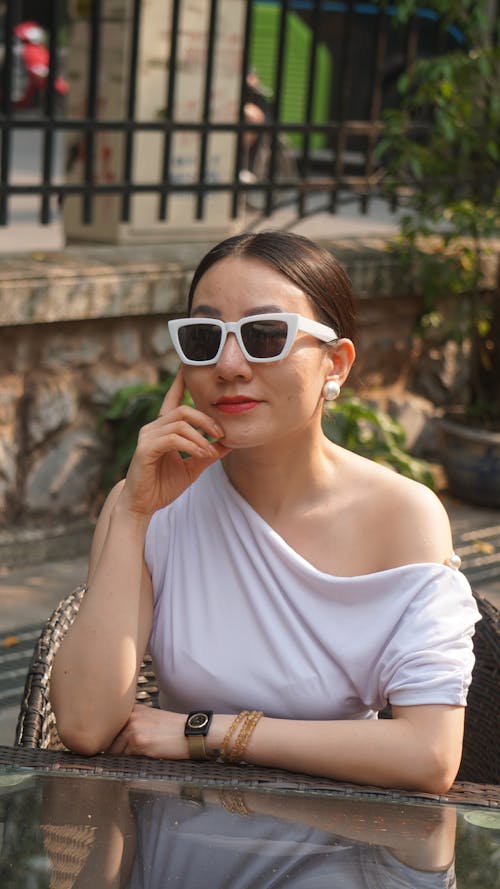 Woman Posing in Sunglasses by Table