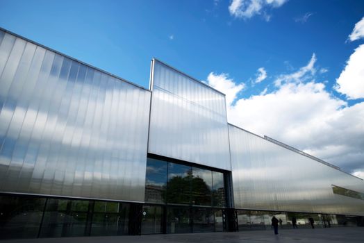 Contemporary art museum exterior with reflective glass facade against a blue sky.