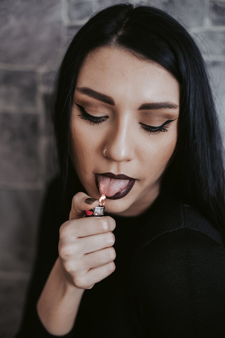 Woman Posing With Lighter Flame Over Tongue