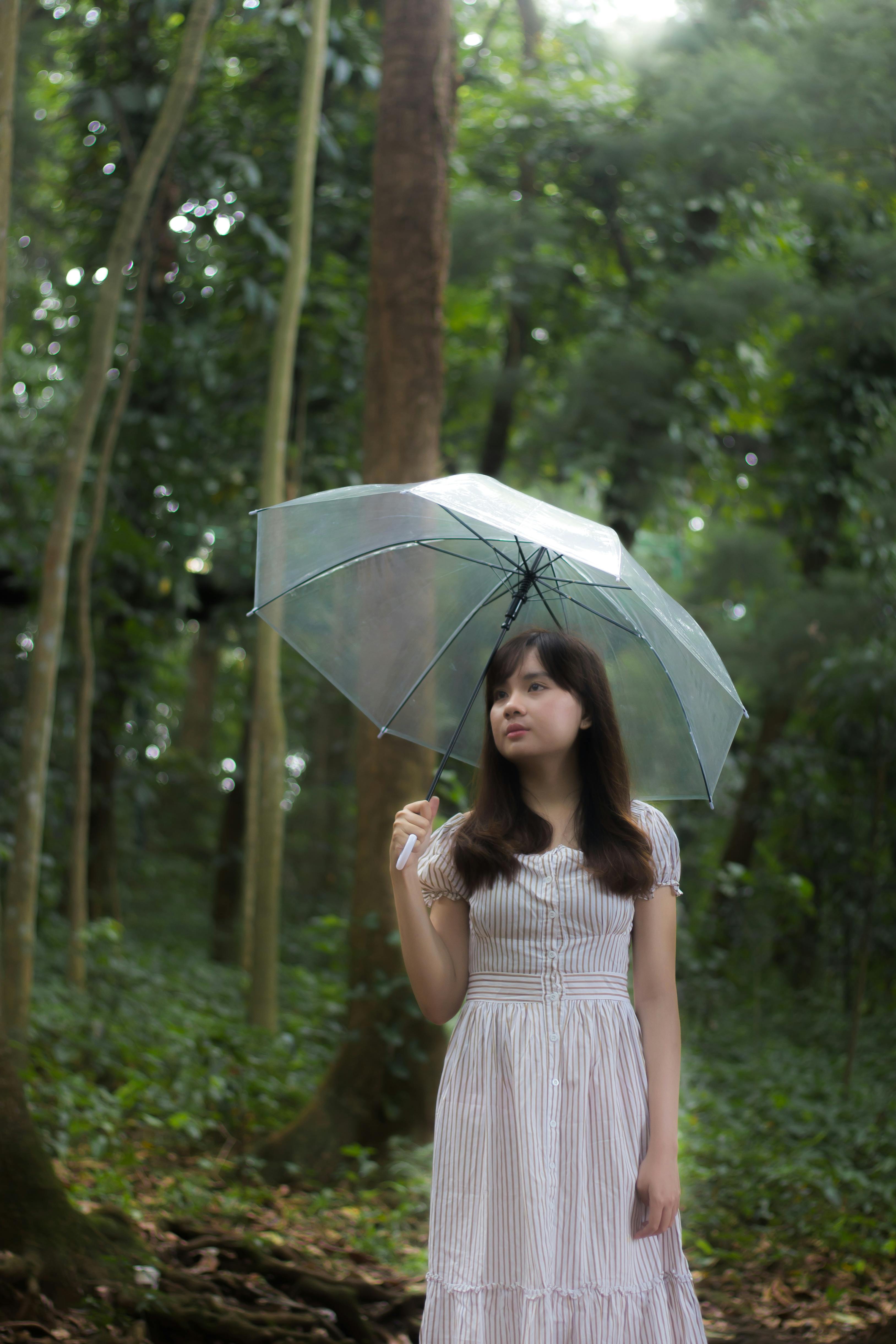 a woman in a white dress holding an umbrella